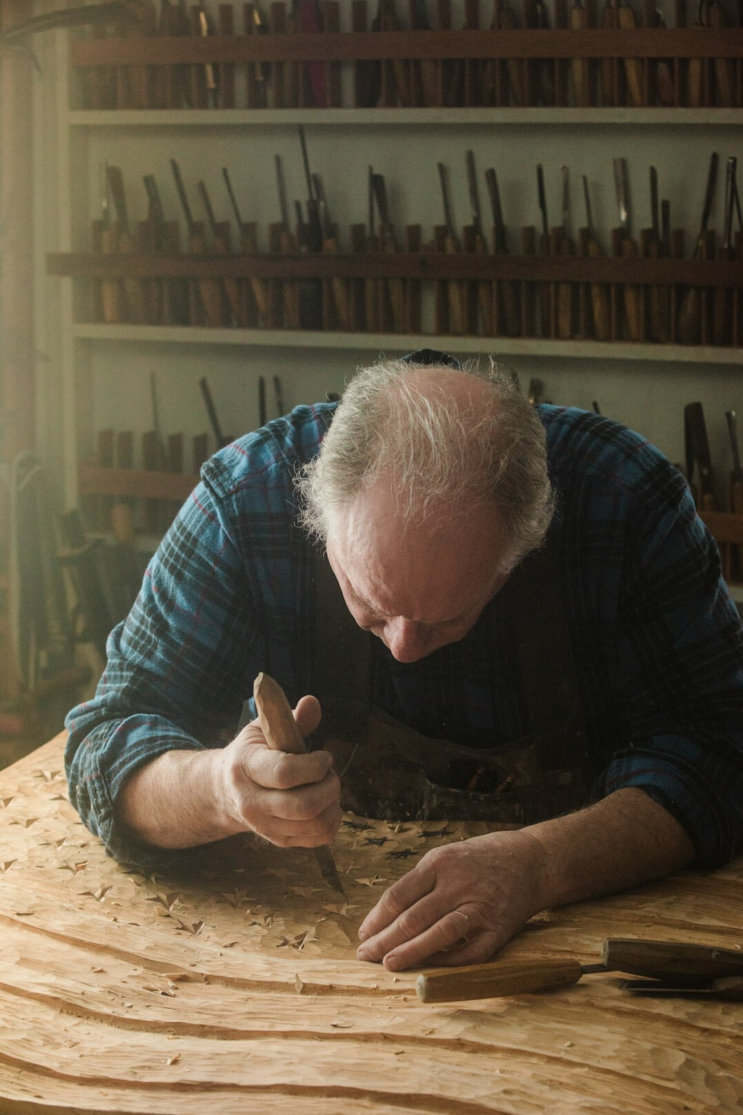 Elderly Polish craftsman working with wood in his workshop