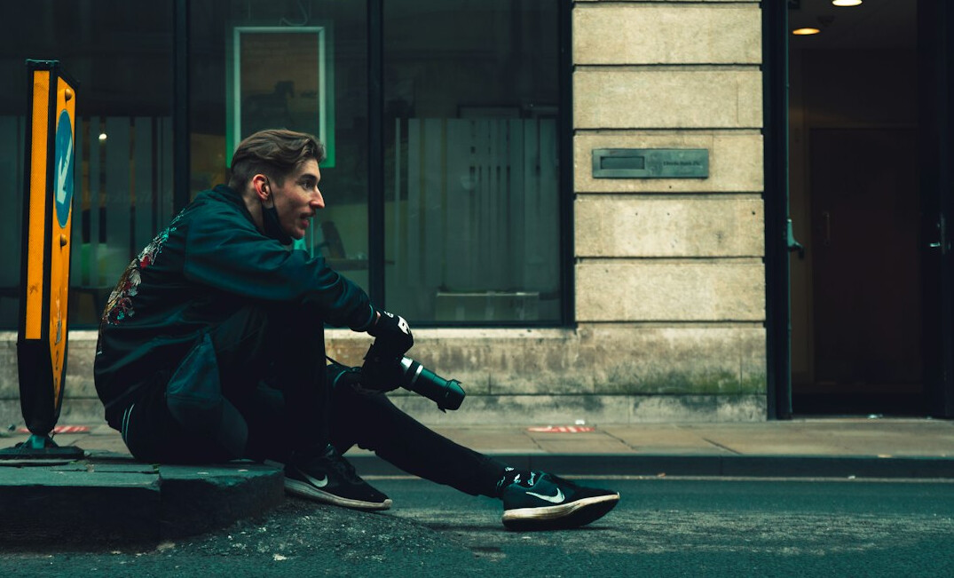 Photographer crouching to take a photo of a street scene